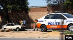 Traffic police fine a motorist in Johannesburg. Robert van Rensburg says if they stop him for drunken driving, he simply bribes them to let him go. (D. Taylor/VOA)