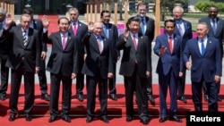 Leaders attending the Belt and Road Forum wave as they pose for a group photo at the Yanqi Lake venue on the outskirt of Beijing, China, May 15, 2017