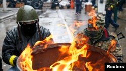 Slaviansk ရဲဌာနချုပ်ဘေးမှာ မီးလှုံနေကြတဲ့ ရုရှားလိုလားသူ လက်နက်ကိုင်များ။ (ဧပြီ ၁၃၊ ၂၀၁၄)