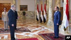 FILE - In this photo provided by Egypt's state news agency MENA, Egyptian President Abdel-Fattah el-Sissi, right, presides over the swearing in of Prime Minister Sheriff Ismail, in Cairo, Sept. 12, 2015.