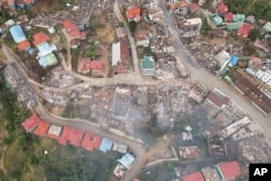FILE - In this aerial photo released by the Chin Human Rights Organization, buildings are seen destroyed by fires in the town of Thantlang, in Chin State, in northwest Myanmar, Dec. 4, 2021.