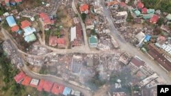 In this aerial photo released by the Chin Human Rights Organization, buildings are seen destroyed by fires in the town of Thantlang, in Chin State, in northwest Myanmar, Dec. 4, 2021. 