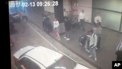 Gambar CCTV tertanggal 13 Februari 2017 yang diunggah hari ini (15/3), menunjukkan seorang perempuan (tengah, berbaju putih) di bandara internasional Sepang, Malaysia, yang ditangkap karena diguda terkait dengan pembunuhan Kim Jong-nam, kakak tiri pemimpin Korea Utara Kim Jong-un (Foto: Star TV via AP).