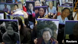 FILE - Students hold portraits of deceased former South Korean "comfort women" during a weekly anti-Japan rally in front of the Japanese Embassy in Seoul, South Korea.