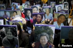 FILE - Students hold portraits of deceased former South Korean "comfort women" during a weekly anti-Japan rally in front of the Japanese Embassy in Seoul, South Korea.