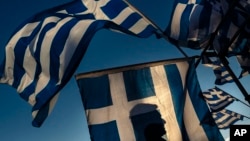 지난 6월 그리스 아테네의 의회 건물 앞에서 구제금융 지지자들이 국기를 휘날리고 있다. (자료사진)