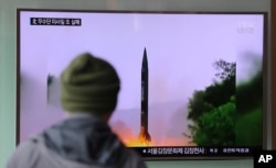 FILE - A man in South Korea watches a TV news program showing a missile launch conducted by North Korea.