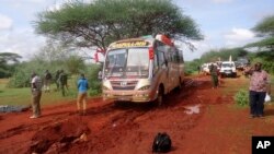 Kenyan security forces and others gather around the scene on an attack on a bus about 50 kilometers (31 miles) outside the town of Mandera, near the Somali border in northeastern Kenya, Saturday, Nov. 22, 2014.