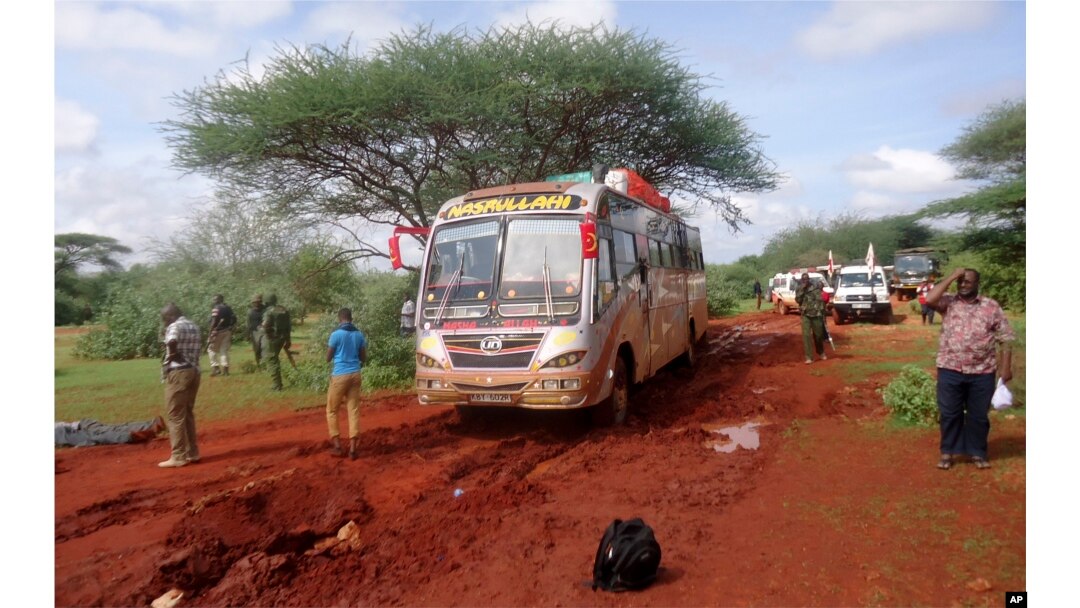 FILE - Kenyan security forces and others gather around the scene on an attack on a bus about 50 kilometers (31 miles) outside the town of Mandera, near the Somali border in northeastern Kenya, Nov. 22, 2014.
