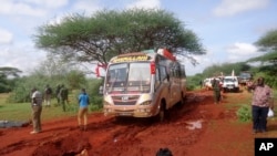 Kenyan security forces and others gather at the scene of a bus attack near the town of Mandera, close to the Somali border, Nov. 22, 2014.