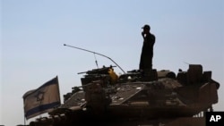 An Israeli soldier on a tank in a staging area near the Israel-Gaza border, Aug. 2, 2014.