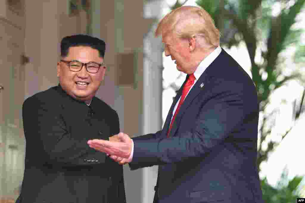 도널드 트럼프 미국 대통령이 12일 싱가포르 카펠라 호텔에서 열린 미북 정상회담에 앞서 김정은 북한 국무위원장과 악수하며 왼손으로 단독회담장 방향을 가리키고 있다.