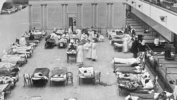 FILE - In this 1918 file photo made available by the Library of Congress, volunteer nurses from the Red Cross tend to influenza patients in the Oakland Municipal Auditorium, used as a temporary hospital. (Edward A. "Doc" Rogers/Library of Congress)