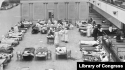 FILE - In this 1918 file photo made available by the Library of Congress, volunteer nurses from the Red Cross tend to influenza patients in the Oakland Municipal Auditorium, used as a temporary hospital. (Edward A. "Doc" Rogers/Library of Congress)