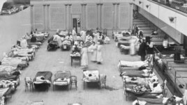 FILE - In this 1918 file photo made available by the Library of Congress, volunteer nurses from the Red Cross tend to influenza patients in the Oakland Municipal Auditorium, used as a temporary hospital. (Edward A. 
