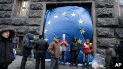 Protesters cover an entrance to the Cabinet of Ministers with a huge EU flag in Kyiv, Ukraine, Dec. 2, 2013. 