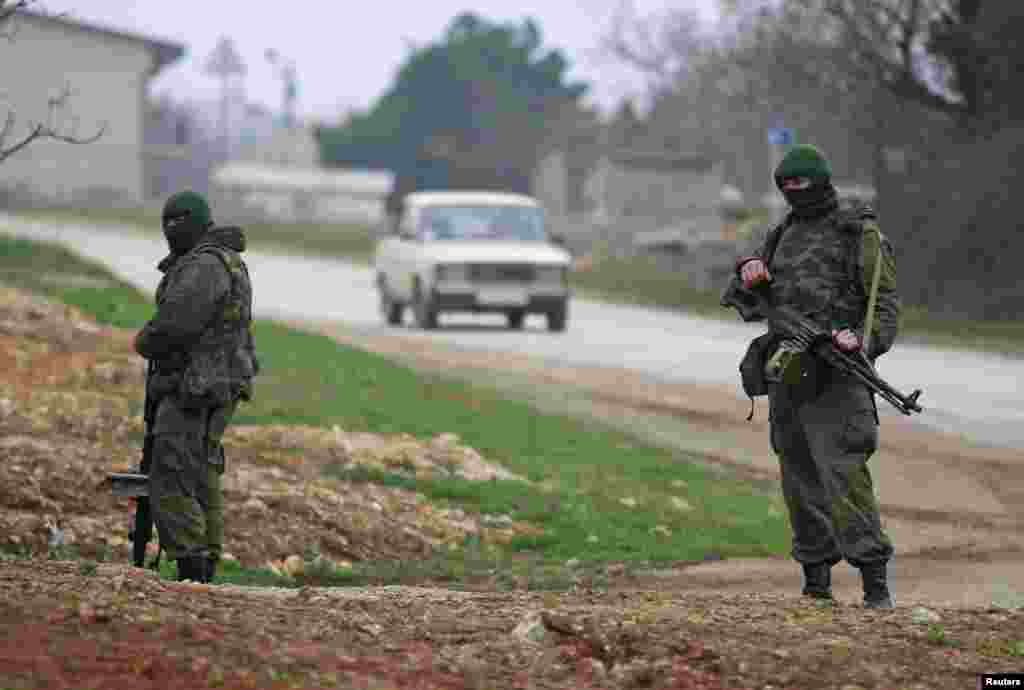 Uniformed men, believed to be Russian servicemen, stand guard near a Ukrainian military base outside the city of Sevastopol, March 7, 2014. 