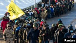 Members of various anti-government paramilitary groups march along a street during a show of force in Kyiv, Jan. 29, 2014. 