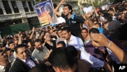 Egyptian Copts, one holding a banner with a picture of Jesus Christ and writing in Arabic reading "Christ, Our God, is alive", demonstrate against the overnight sectarian violence, in downtown Cairo, Egypt Sunday, May 8, 2011.