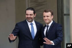 French President Emmanuel Macron, right, poses for photographers with Lebanon's Prime Minister Saad Hariri prior to their meeting at the Elysee Palace in Paris, Saturday, Nov. 18, 2017.