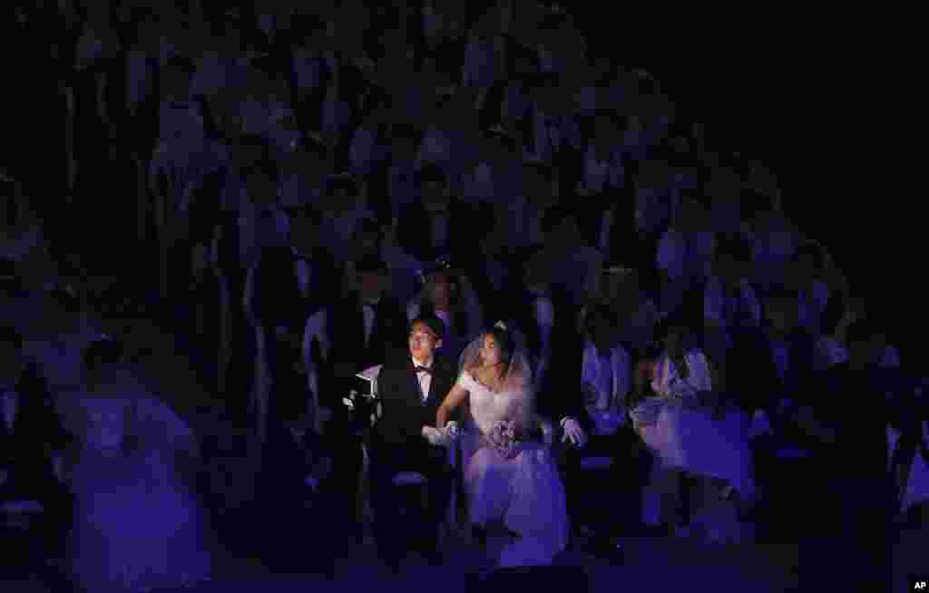 한국 가평 청심평화월드센터에서 열린 합동결혼식에서 한 커플이 스크린을 바라보고 있다. 세계평화통일가정연합 주재한 이날 합동결혼식에서는 4000여쌍의 신랑신부들이 결혼식을 올렸다.