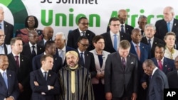 French President Emmanuel Macron, center left, speaks with Morocco's King Mohammed VI, center right, during a group photo at an EU Africa summit in Abidjan, Ivory Coast on Wednesday, Nov. 29, 2017. 