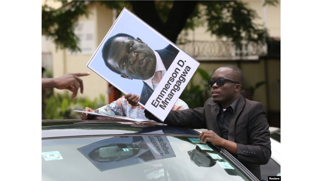 A protester holds a poster showing support for ousted Zimbabwean Vice President Emmerson Mnangagwa, in Harare, Zimbabwe, Nov. 18, 2017. Mnangagwa is to be sworn in as president Wednesday or Thursday.