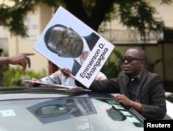 A protester holds a poster showing support for ousted Zimbabwean Vice President Emmerson Mnangagwa, in Harare, Zimbabwe, Nov. 18, 2017. Mnangagwa is to be sworn in as president Wednesday or Thursday.