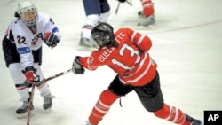 Canada's Caroline Quellette and US Kacey Bellamy vie for puck during gold medal match at the IIHF Women's World Ice Hockey Championships in Finland, 12 Apr 2009