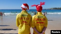 FILE - Volunteer life guards from North Bondi Surf Life Saving Club, keep an eye on swimmers enjoying Christmas day on Bondi Beach, Sydney, Dec. 25, 2018. Australia sweated through one of its hottest Decembers ever, and January wasn't any better.