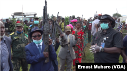 Maheshe et ses lieutenants brandissent des armes à remettre, en RDC, le 20 mai 220. (VOA/Ernest Muhero)
