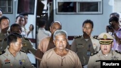 FILE - Lieutenant-General Manas Kongpaen (C) is escorted by officers as he arrives at the criminal court in Bangkok, Thailand, Nov. 10, 2015. 