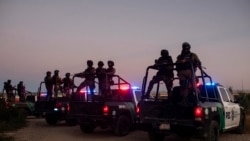 Mexican police stand guard near the Rio Grande River in Ciudad Acuna, Mexico, at dawn Sept. 23, 2021, on the border with Del Rio, Texas.