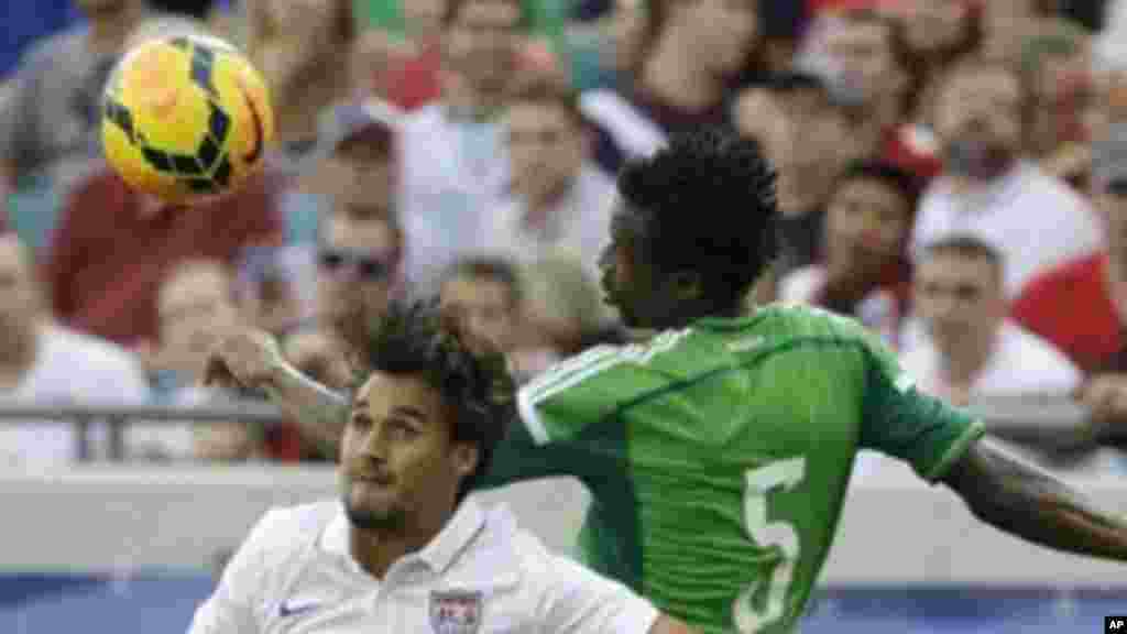 United States' Chris Wondolowski heads the ball away from Nigeria's Efe Ambrose.