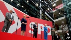 Olaf Scholz, center, top candidate for chancellor of the Social Democratic Party (SPD), speaks during a press conference at the party's headquarters in Berlin, Germany, Monday, Sept. 27, 2021. 