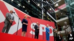 Olaf Scholz, center, top candidate for chancellor of the Social Democratic Party (SPD), speaks during a press conference at the party's headquarters in Berlin, Germany, Monday, Sept. 27, 2021. 