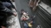 Syria Civil Defence members help an unconscious woman from a shelter in the besieged town of Douma, Eastern Ghouta, Damascus, Syria, Feb. 22, 2018. 