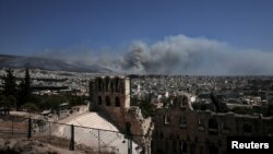 A view of the Herodes Atticus theater as smoke from a raging wildfire rises in Athens, Greece, July 17, 2015. 