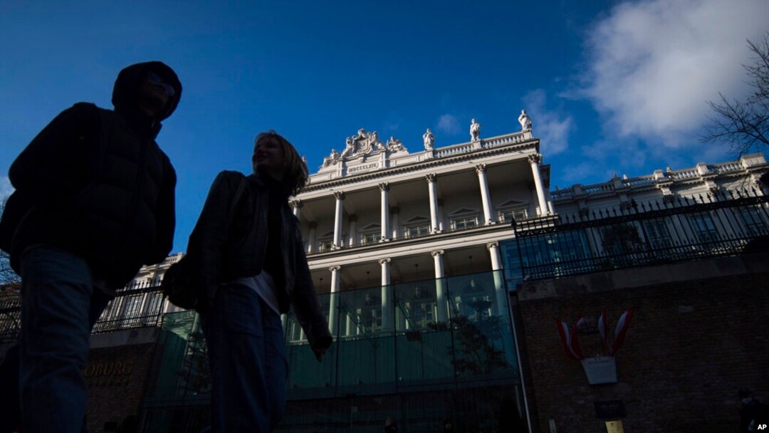 People walk past Palais Coburg, where closed-door nuclear talks take place in Vienna, Austria, Dec. 17, 2021.