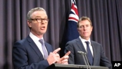 FILE - Australian Government Leader in the House of Representatives Christopher Pyne, left, and Attorney-General Christian Porter address reporters in Parliament House in Canberra, Australia, May 9, 2018.