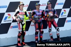 Jorge Martin merayakan pole position bersama Marco Bezzecchi, dan Pedro Acosta usai kualifikasi MotoGP di Sirkuit Mandalika, 28 September 2024. (Foto: Sonny TUMBELAKA/AFP)