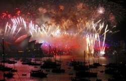 Fuegos artificiales iluminan el Sydney Harbour Bridge y la Ópera de Sydney durante las celebraciones de año nuevo en el puerto de Sydney. enero 2020.