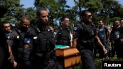 Policemen carry the coffin of military police officer Felipe Santos Mesquita, who was shot dead during a clash with drug gangs in Rocinha slum, during the burial in Rio de Janeiro, Brazil, March 23, 2018. 
