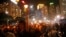 People hold candles under heavy rain as tens of thousands of people attend a candlelight vigil to mark the 24th anniversary of the June 4 Chinese military crackdown on the pro-democracy movement in Beijing, at Victoria Park in Hong Kong, June 4, 2013.