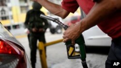 Un trabajador, conocido como "bombero", llena el tanque de un auto en una estación de servicio de Caracas, Venezuela, en mayo de 2020. La gasolina ha escaseado en la mayoría de las regiones del país en las últimas semanas.