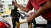 Un trabajador sostiene una bomba de gasolina en una gasolinera de la petrolera estatal PDVSA en Caracas, Venezuela. Mayo 25, 2020. Foto: AP.