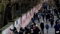 People paint red hearts onto the COVID-19 Memorial Wall mourning those who have died, opposite the Houses of Parliament on the Embankment in London, Monday, April 5, 2021. Hearts are being painted onto the wall in memory of the many thousands of…