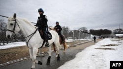 Mounted police ride past a security fence in Washington, DC, on January 18, 2025, as the US capital prepares for the inauguration of US President-elect Donald Trump January 20. (Photo by ANDREW CABALLERO-REYNOLDS / AFP)