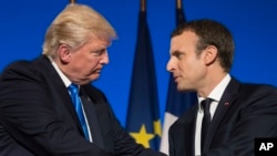 Presiden AS Donald Trump dan Presiden Perancis Emmanuel Macron berjabat tangan usai konferensi pers bersama di Istana Elysee di Paris, Kamis (13/7). 