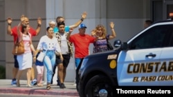 Shoppers exit with their hands up after a mass shooting at a Walmart store in El Paso, Texas, Aug. 3, 2019.